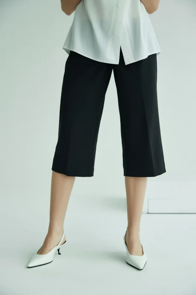 Tailored black capri pants with kitten heels and white blouse in a modern editorial early 2000s fashion look