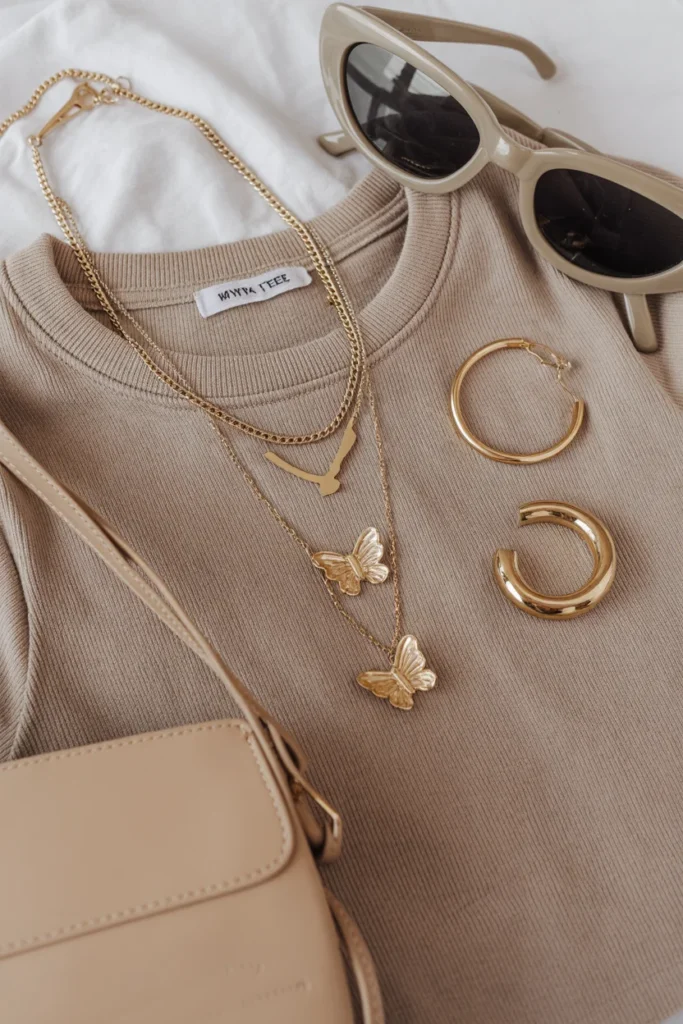 Y2K accessories for baby tee outfits including layered necklaces, butterfly clips, and a mini shoulder bag